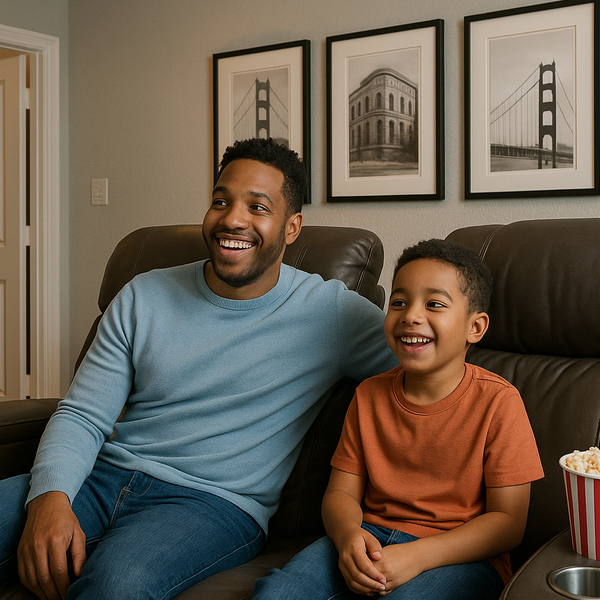 Father and son sitting in comfortable home theater seating in the media room of their new Perry Home Theyre delighted-1-1-1