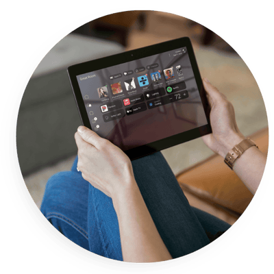 Person using a tablet to control a smart home system, adjusting lighting, audio, and settings through an intuitive app, highlighting convenient, centralized home automation.