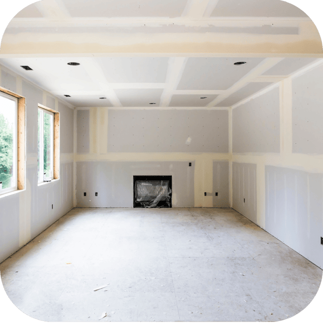 Unfinished interior room with drywall, recessed lighting cutouts, and fireplace, highlighting new construction or pre-wire stage ready for smart home and low-voltage system installation.