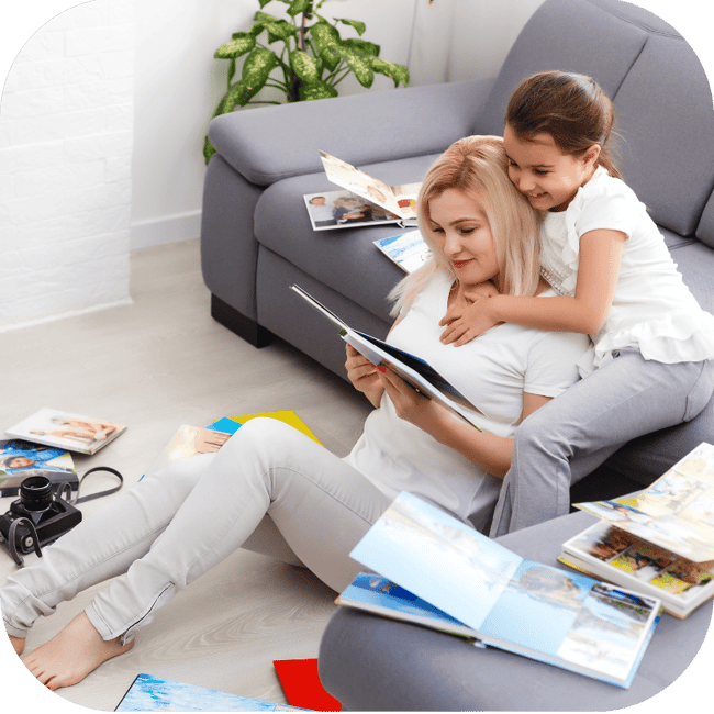 Mother and daughter relaxing on the floor reading together beside a couch, highlighting a comfortable, family-focused home environment and everyday living in houston, texas.