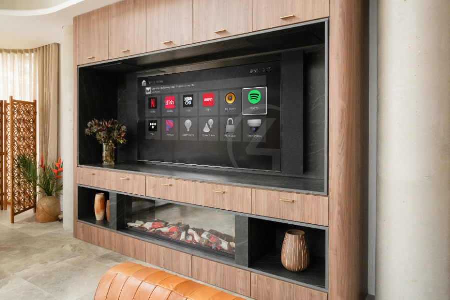 Built-in wall unit with a large integrated display showing a smart home dashboard above a fireplace, highlighting seamless home automation and custom-designed media integration.